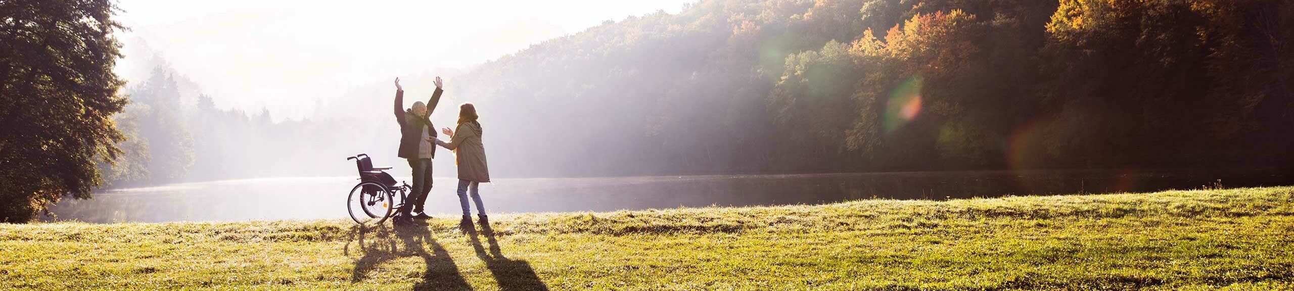 senior and nurse walking at lake