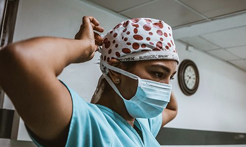 mask nurse putting on her covid mask