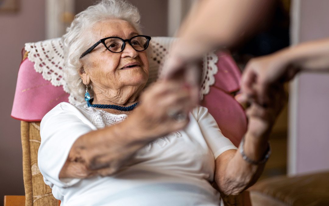 nurse holding hands with cute elderly woman