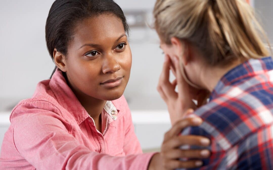 A stressed out caregiver who is talking to her friend for support