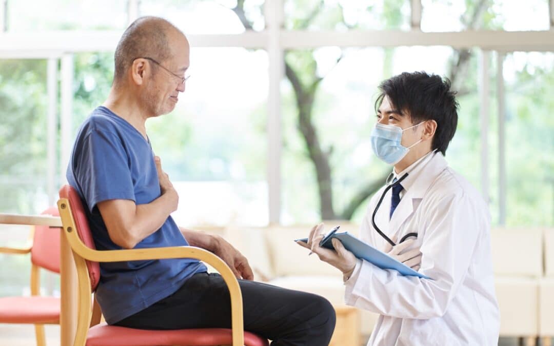 A doctor talking to an elderly man in a long-term care facility