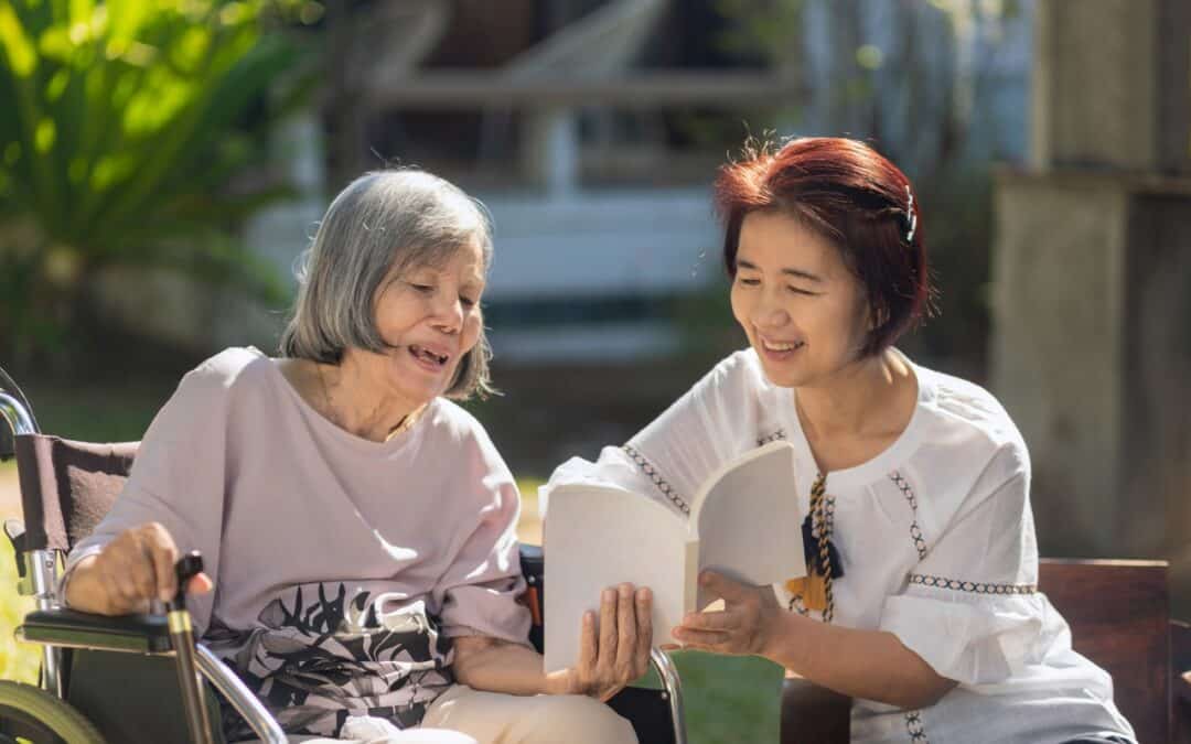 An elderly woman reading a book with her daughter