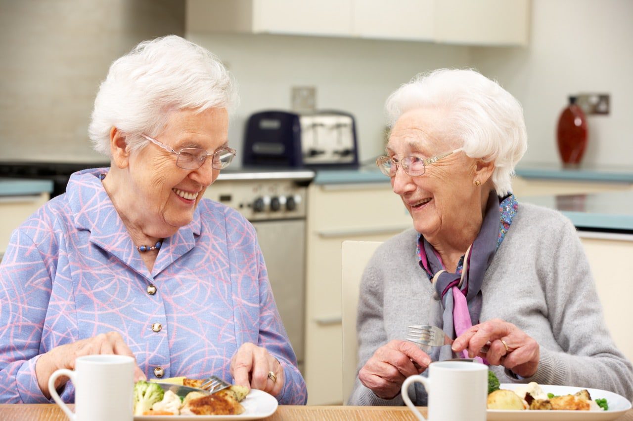 Two seniors talking in a kitchen