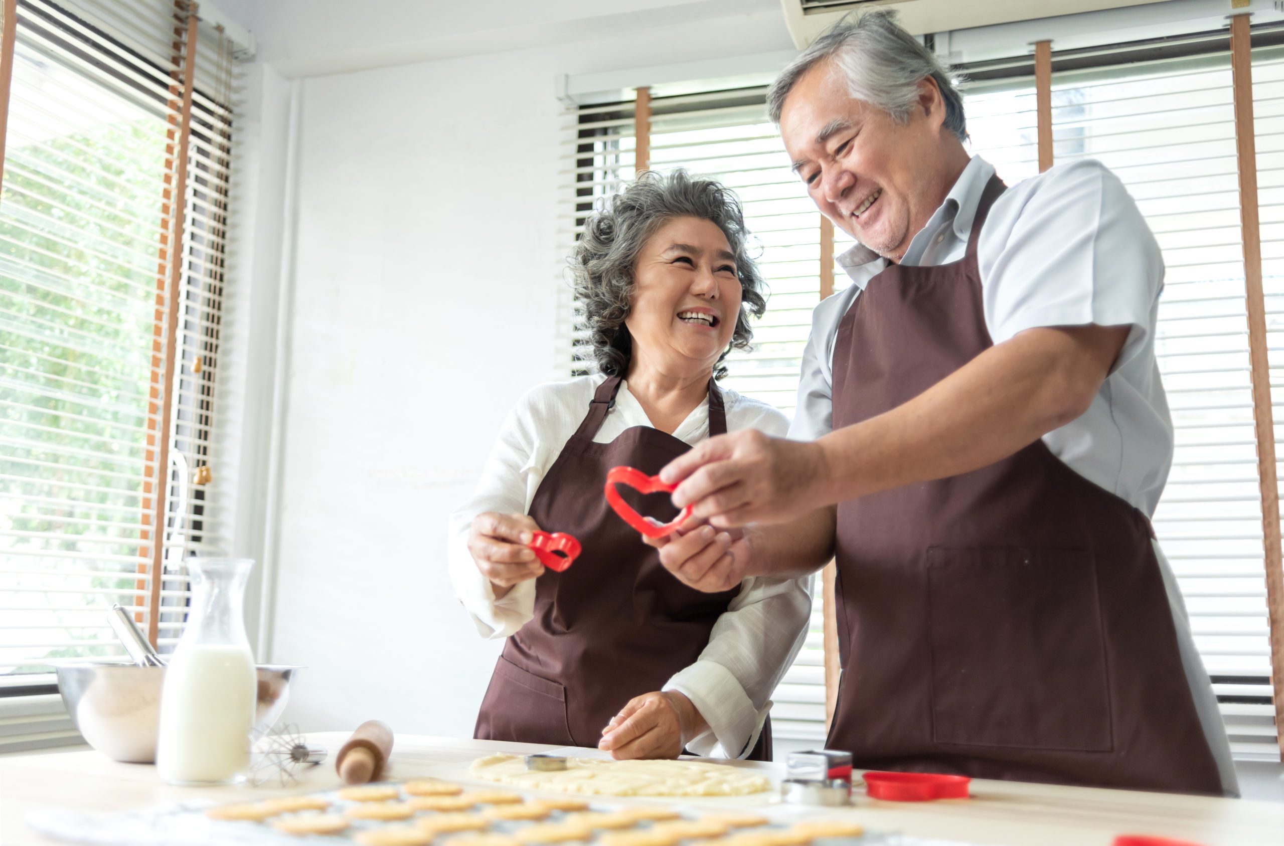 An elderly man and woman spending Valentine's Day together baking at home