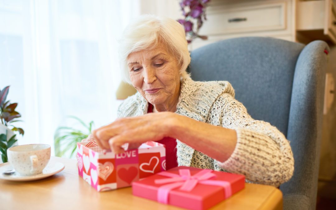 An elderly woman opening a Valentine's Day gift