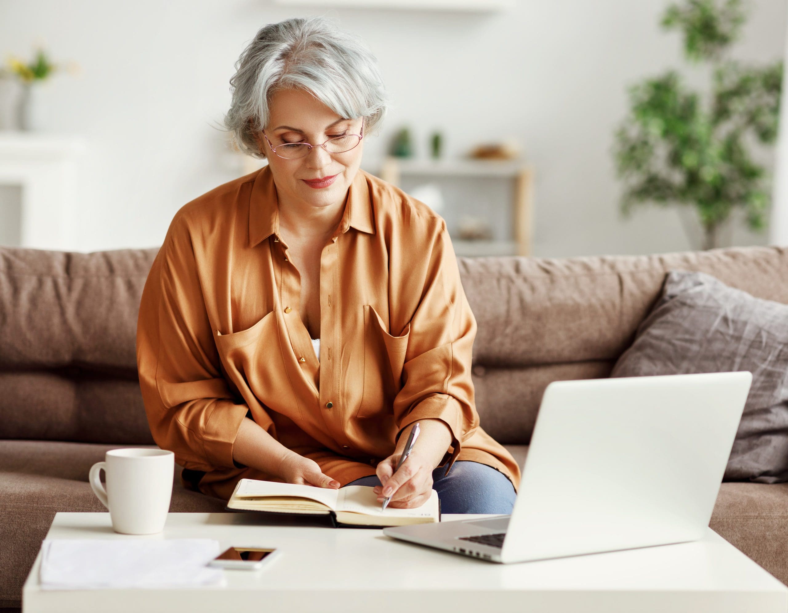 An elderly woman using her laptop independently